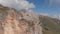 Aerial shot of a group of climbers on top of a mountain pulling a rope.