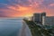 aerial shot of hotels, luxury condos and skyscrapers along the coastline at sunrise at Bal Harbour Beach, blue ocean water