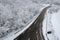Aerial shot of the Italian Apennines road covered in snow in Vezzolacca, Italy