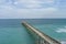 aerial shot of Johnnie Mercer\\\'s Fishing Pier with vast blue ocean water and people walking along the pier, blue sky