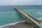 aerial shot of Johnnie Mercer\\\'s Fishing Pier with vast blue ocean water and people walking along the pier, blue sky