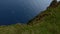 Aerial shot of Kallur lighthouse and a cliffed coast in Kalsoy, Faroe Islands