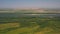 Aerial shot of a land covered in greens and  a long river