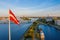 Aerial shot of the Latvian flag waving in the blue sky in Riga, Latvia