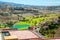 Aerial shot of a luxury hotel with golf courts, pond, and hills in Gran Canaria, Spain