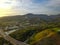 An aerial shot of the majestic mountain ranges with homes along the coastline of California, freeways with cars and powerful cloud