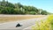 Aerial shot of man riding fast on modern sport motorbike at highway during summer day. Motorcyclist racing his