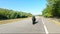 Aerial shot of man riding fast on modern sport motorbike at highway during summer day. Motorcyclist racing his