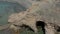 Aerial shot of a man standing on a cliff above sea