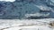 Aerial shot of a man walking on a helipad covered with snow revealing huge mountains in the background