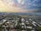 Aerial shot of the office buildings, apartments and shops in the city skyline surrounded by a river, lush green trees, roads and