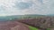 Aerial shot over almond trees and green hills