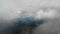 Aerial shot over mountains at sunny day with a lot of clouds into the sky.