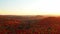 Aerial shot panning from right to left over colorful mountains in the park of Mont-Loup-Garou when the sun is setting