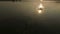 Aerial shot of a picturesque lake and a man swimming crawl at sunset