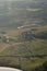 Aerial shot of rural countryside with green forest areas, crop fields, roads and farms. Beautiful nature captured from an airplane