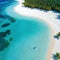 Aerial shot of a secluded tropical beach with crystal clear palm and a couple of beach Perfect for advertising a