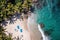 Aerial shot of a secluded tropical beach with crystal clear water, palm trees, and a couple of beach chairs. Perfect for