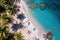 Aerial shot of a secluded tropical beach with crystal clear water, palm trees, and a couple of beach chairs. Perfect for