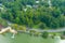 An aerial shot of the silky green waters of the lake surrounded buy lush green trees and a smooth footpath circling the water