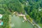 An aerial shot of the silky green waters of the lake surrounded buy lush green trees and a smooth footpath circling the water