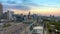 aerial shot of the skyscrapers, office buildings and tower cranes in the city skyline with cars and trucks driving on the freeway