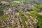 Aerial shot of a small town in a picturesque landscape of lush green fields in the countryside