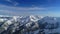 Aerial shot of snowy mountain peak.