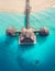 Aerial shot of the Stilt hut with palm thatch roof washed with turquoise Indian ocean waves on the white sand sandbank beach on