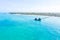 Aerial shot of the Stilt hut with palm thatch roof washed with turquoise Indian ocean waves on the white sand sandbank beach on