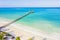 Aerial shot of the Stilt hut with palm thatch roof washed with turquoise Indian ocean waves on the white sand sandbank beach on