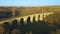 Aerial shot of the stone railway bridge in sunset with interesting shadow 4k