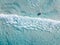 Aerial shot of swimmers on a beautiful beach with blue water and white sand