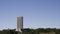 Aerial shot of a tall building surrounded by forested hills