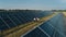 Aerial shot of three solar energy engineers on a large solar farm. Three employees of alternative power plant walking