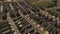 Aerial shot tilting down on dense suburban housing development with park