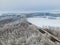 Aerial shot of trees, highway and field covered with snow on a cold winter day