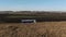 Aerial shot of a truck on the road in beautiful countryside. Truck moves on dirt road on corn field background. Semi