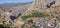 Aerial shot of a village hidden in tremendous mountains and gorges of nature