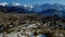 Aerial shot of a village surrounded by giant breathtaking  mountains covered  in snow