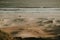 Aerial shot of the wavy ocean hitting the golden sandy beach in Rio de Janeiro