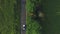 Aerial shot of white convertible car riding through empty rural road. Four young unrecognizable women travelling at