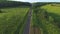 Aerial shot of white convertible car riding through empty rural road. Four young unrecognizable women travelling at