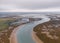 Aerial shot of a wide river slowly flowing through the vast valley