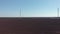 Aerial shot of windmill with large blades rotating by wind. Wind turbine is generating renewable energy in green ecological way. A