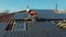 Aerial shot of worker with orange jaket installing solar panel installed on home rooftopequipttt