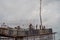 Aerial shot of workers standing on the support of a bridge with rebar structure exposed using a crane to pour concrete