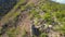 Aerial shot of a young man sitting on a rock in mountains. Hiking concept