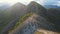 Aerial shot of a young man standing on top of the hill in mountains. Hiking concept