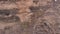 Aerial shots of a herd of mountain goats running on a steep mountain.